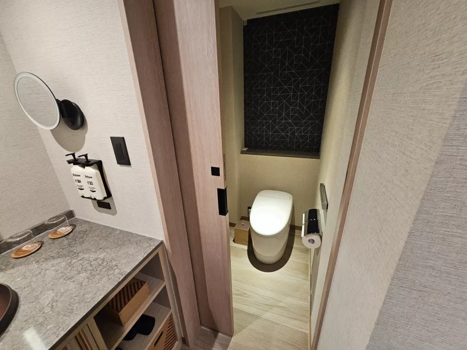 Separated toilet from the rest of the bathroom by a door